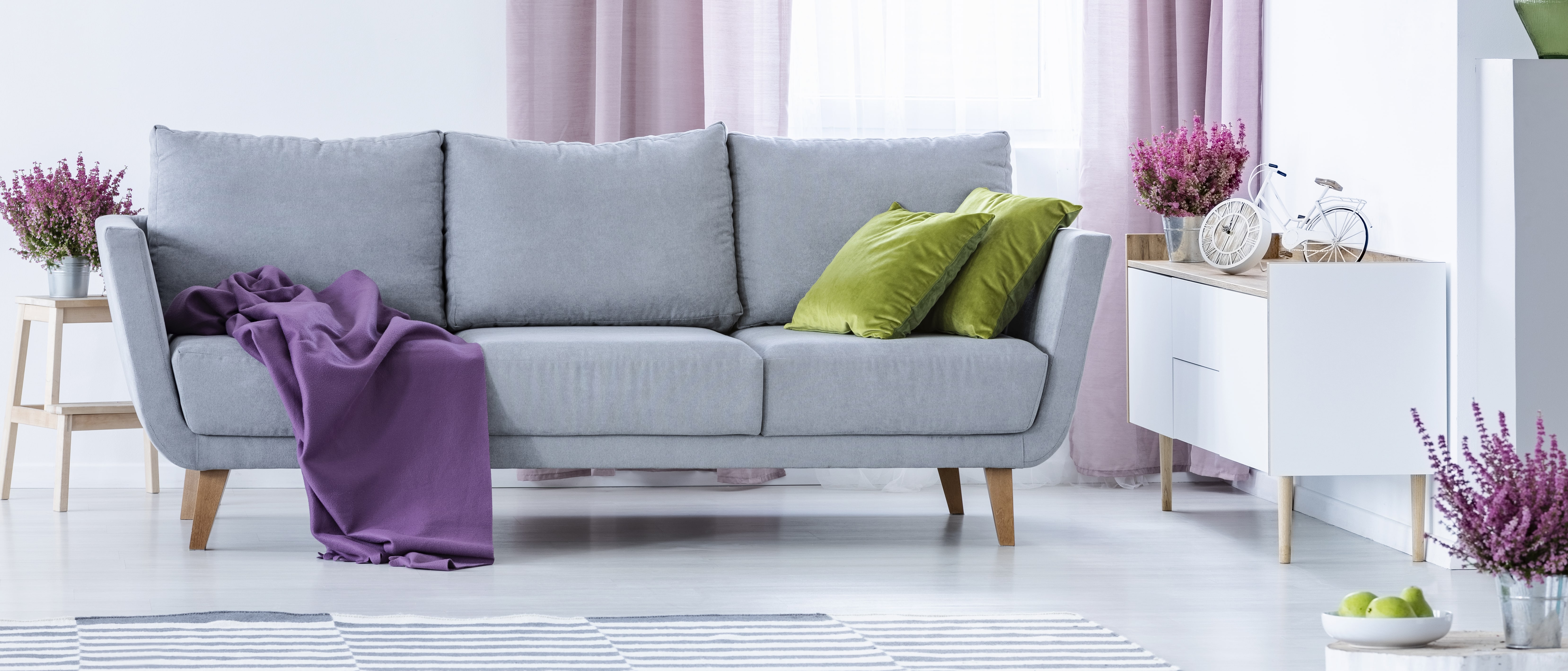 grey-couch-with-purple-blanket-and-green-pillows-2BRPWJA-min